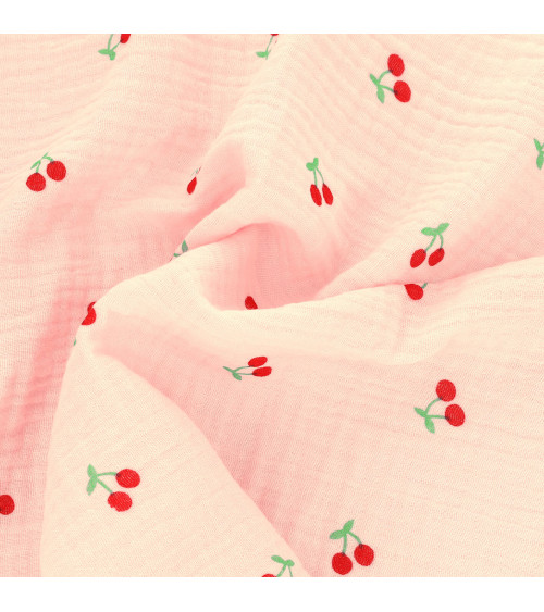 Tela gasa doble con estampado de cerezas y fondo rosa por metros