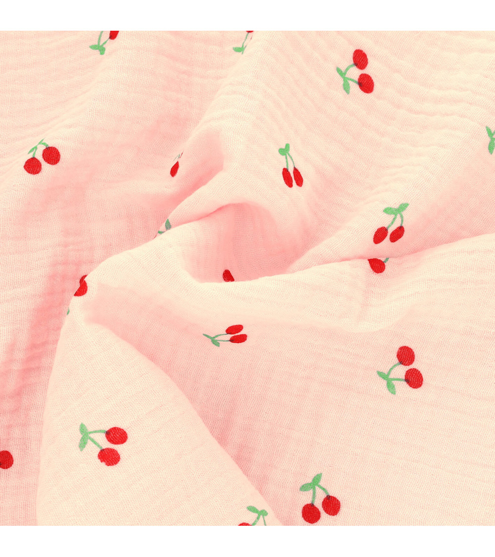 Tela gasa doble con estampado de cerezas y fondo rosa por metros